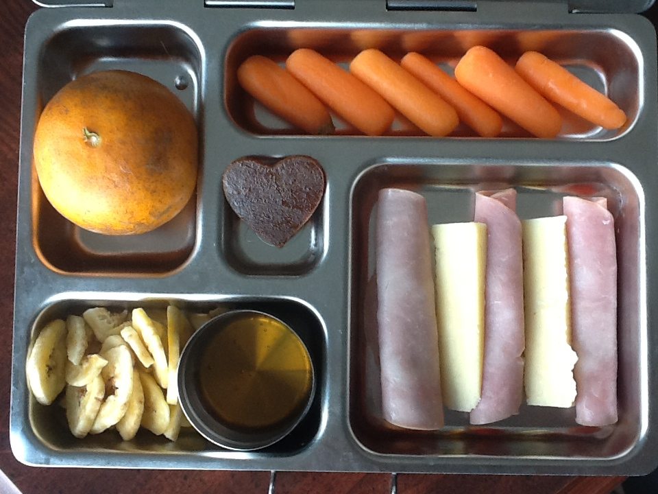 Tangerine, carrots, ham roll ups, Kerrygold cheese, banana chips and raw honey, and a apricot leather heart!